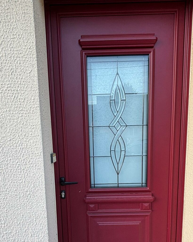 Porte d’entrée en aluminium bordeaux avec vitrage décoratif et serrure multipoint