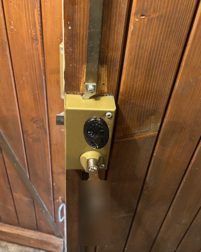 Serrure en applique avec cylindre sur un portail en bois