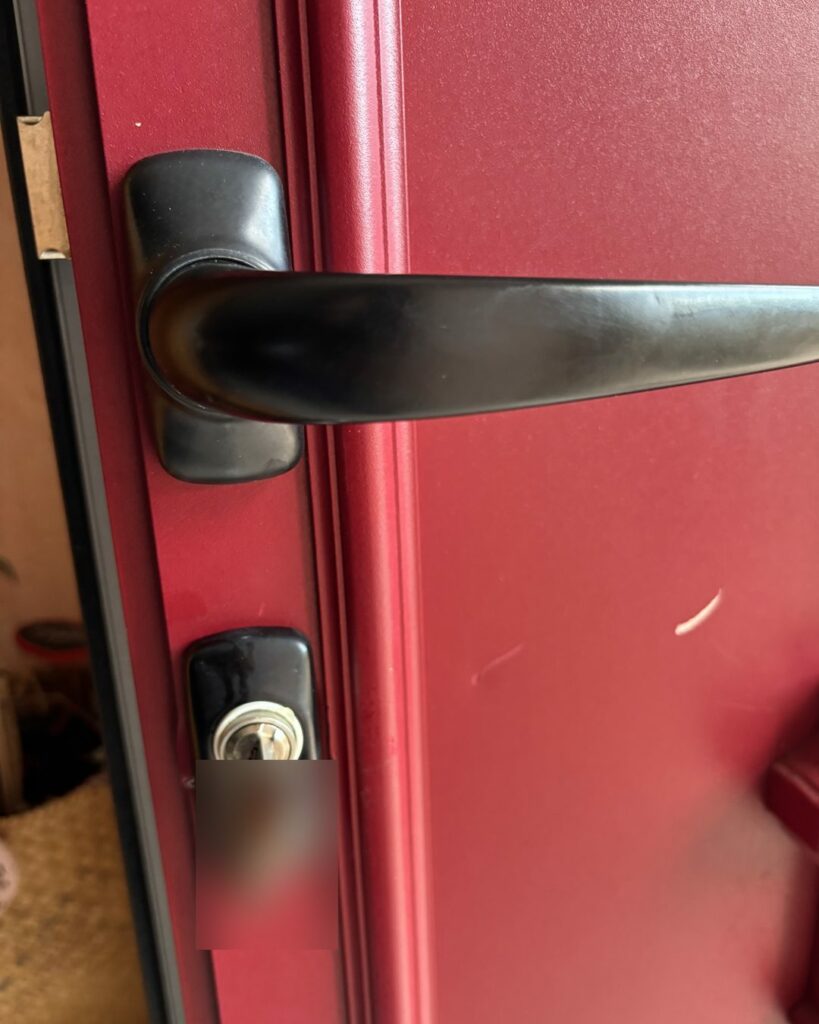 Poignée et cylindre de serrure sur une porte d’entrée rouge